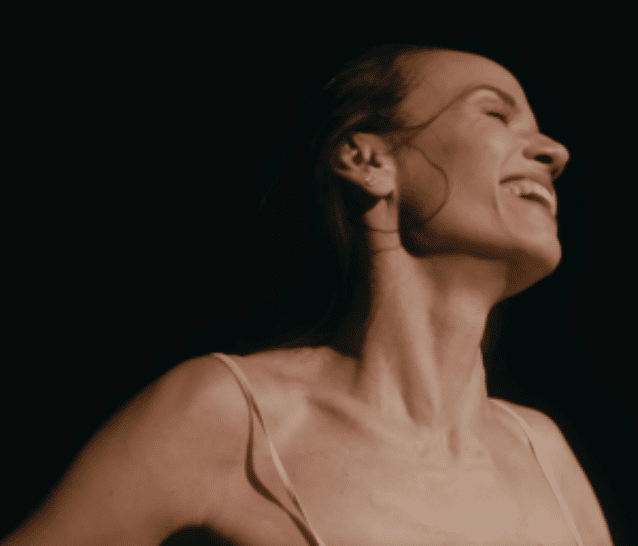 Primo piano di una performer sorridente che esprime gioia e libertà. Connettiamoci per creare insieme e instaurare relazioni umane attraverso l'arte.