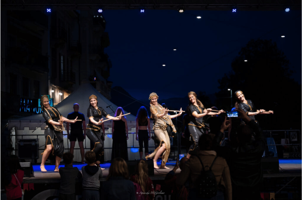 Performance di danza popolare che trasforma il movimento in un'esperienza condivisa, connettendo persone oltre le barriere culturali.