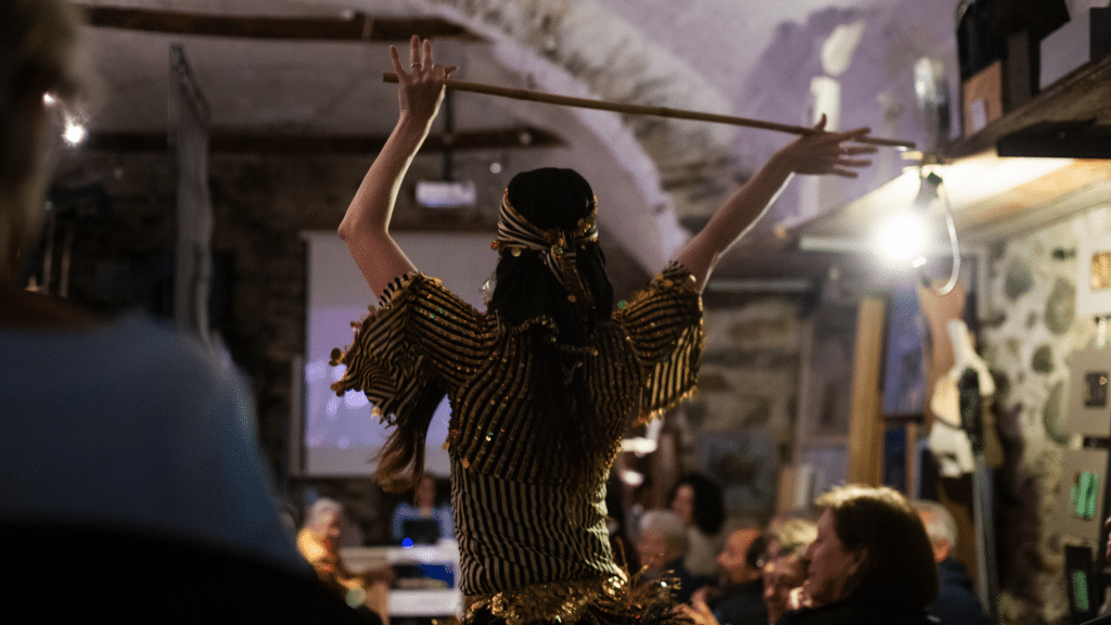 Danzatrice di folklore con bastone durante una performance culturale di Wide Company.